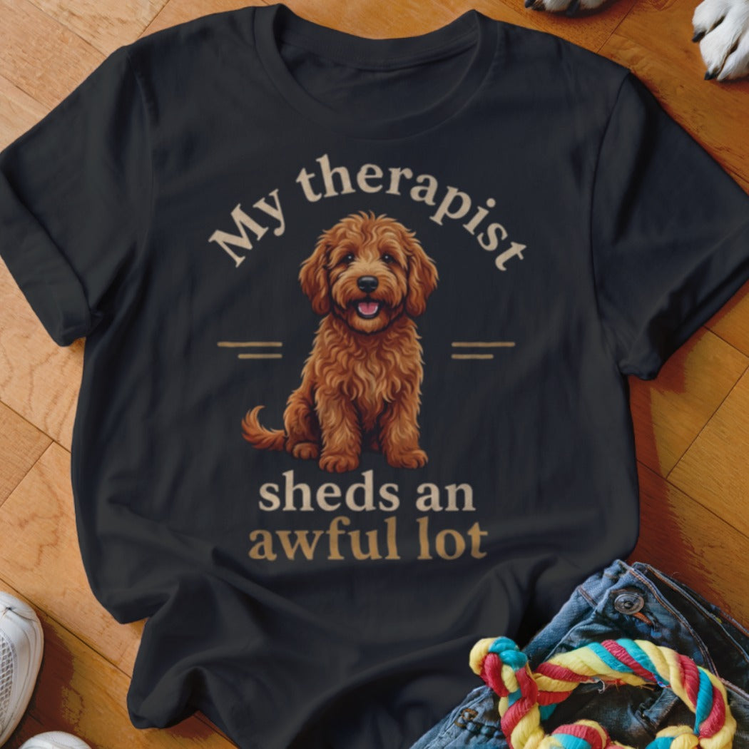 Black t-shirt with a cartoon goldendoodle and text "My therapist sheds an awful lot."